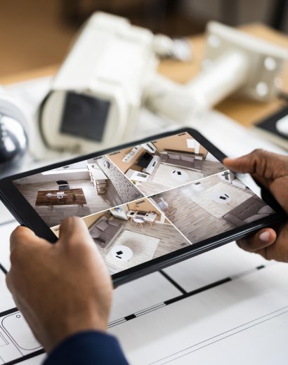 Man in Manchester viewing live CCTV footage on a tablet, showing multi-camera security feed
